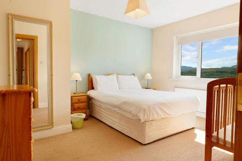 a bedroom with a large bed and a window at Bradleys Cottage Creeslough in Creeslough