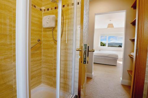 a shower with a glass door in a bathroom at Bradleys Cottage Creeslough in Creeslough