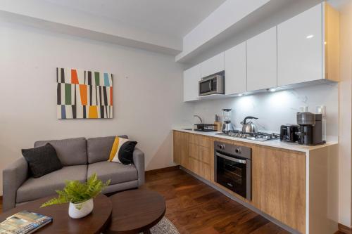 a living room with a couch and a kitchen at DOMINION SANTA FE in Mexico City