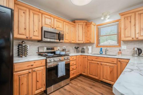 a kitchen with wooden cabinets and a black refrigerator at Grand Palace in Sioux Falls