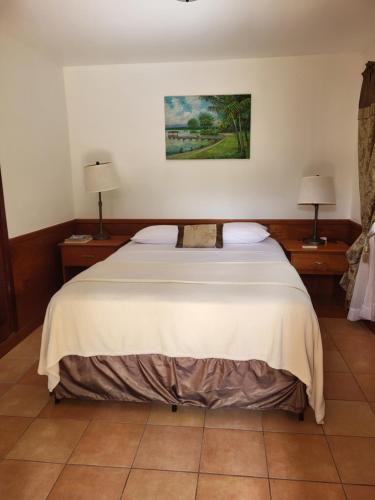 a bedroom with a large bed with two night stands at Los Olingos Lodge in Tela