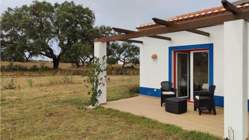 mały biały dom z drewnianym tarasem w obiekcie Monte da Isabel w mieście Vale de Água