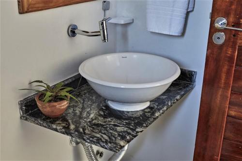 baño con lavabo blanco en una encimera de mármol en Condomínio Villa Conduru - Casa completa en Prea