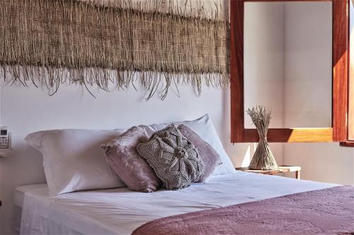 un letto con un cuscino sopra di Condomínio Villa Conduru - Casa completa a Prea