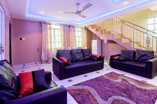 a living room with two couches and a staircase at NKA Properties in Apenkwa