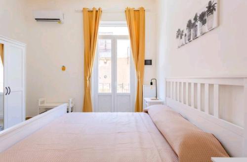una camera da letto con un grande letto con tende arancioni di Merlo House a Palermo