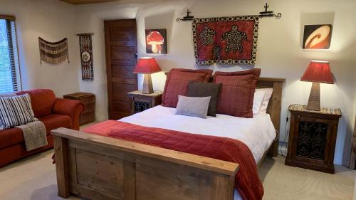 a bedroom with a large bed and a red couch at Tussock Cottage in Queenstown