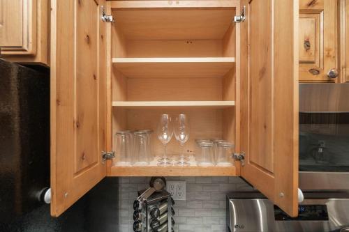 a kitchen with wooden cabinets with wine glasses in it at Grand Palace in Sioux Falls