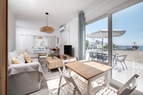 un soggiorno con divano e tavolo con sedie di Thalassa Beach House a Kefalos
