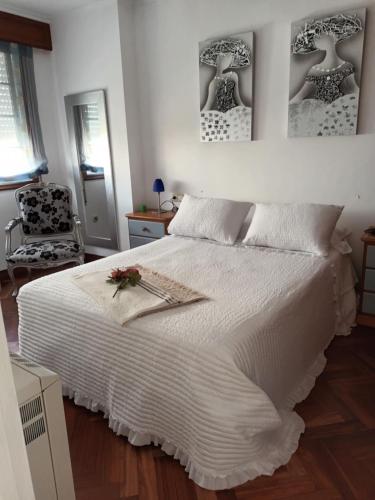 1 dormitorio con 1 cama blanca y 1 silla en Portosin puerto, en Portosín