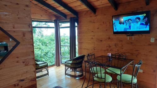 a dining room with a table and a television on a wall at El Descanso Restaurante y Hotel in Fraijanes