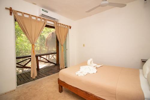 1 dormitorio con cama y ventana grande en Hotel Ak'Na Holbox en Holbox Island