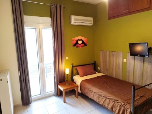 a bedroom with a bed and a tv on the wall at Sunny home crete in Ierápetra