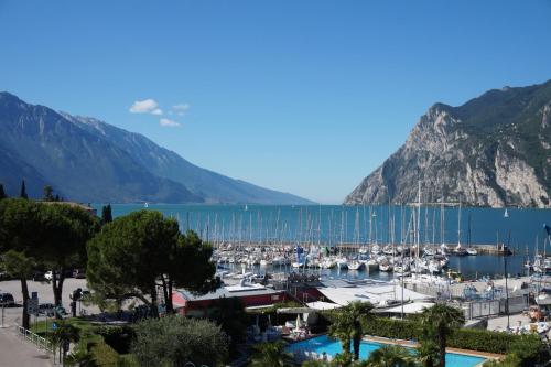 a marina with boats in the water and mountains at Hotel Riviera in Riva del Garda