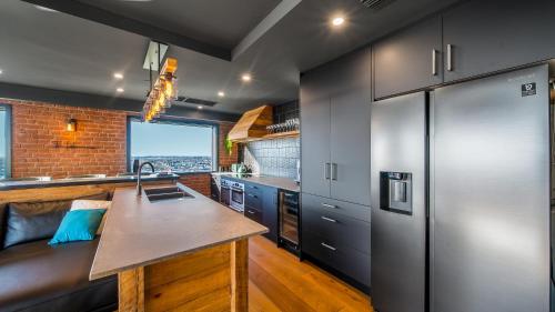 a kitchen with a sink and a counter top at CBD Loft Style Apartment with Free Valet Parking in Christchurch