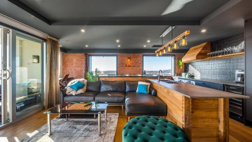 a kitchen and living room with a couch and a counter at CBD Loft Style Apartment with Free Valet Parking in Christchurch