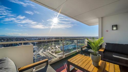 a balcony with a table and chairs and a view at CBD Loft Style Apartment with Free Valet Parking in Christchurch