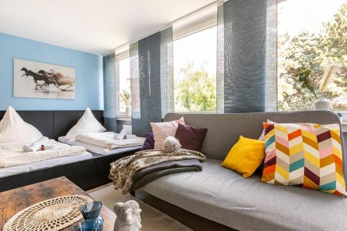 a living room with a couch with colorful pillows at - Heavenly apartment in the heart of Duisburg - 2 Mins Hbf Central Station - Big TV & Working space & Netflix - in Duisburg