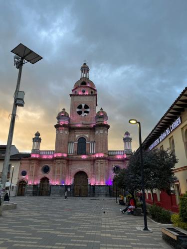 a large building with a clock tower with pink lights at Hermoso apartamento en Pasto. Central parque San Andrés in Pasto