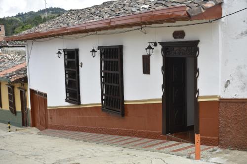 a building with three windows and a door at Casa Patrimonial Abejorral - CASA GASAMA in Abejorral