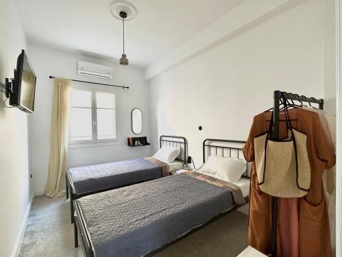 a bedroom with two beds and a window at The Lassis 15 House in Argostoli