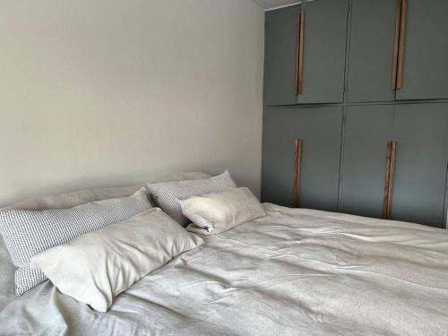 Una cama blanca con dos almohadas encima. en Exclusive Urban Apartment en Mendoza