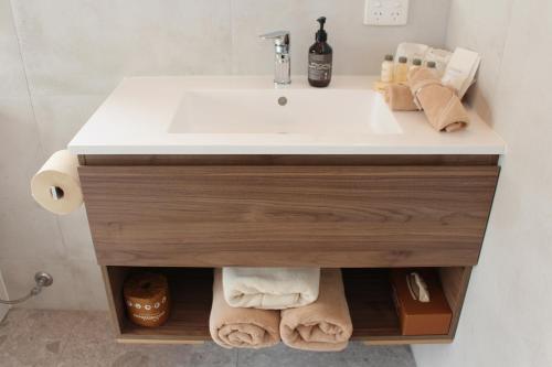 a bathroom vanity with a sink and towels at Little Sherwood Drouin Petting Zoo & Cottages in Drouin West
