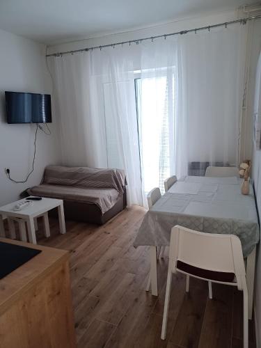 a small bedroom with a bed and a couch at Apartment Banjol 4965b in Rab