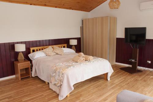 Un dormitorio con una cama con un osito de peluche. en Little Sherwood Drouin Petting Zoo & Cottages en Drouin West