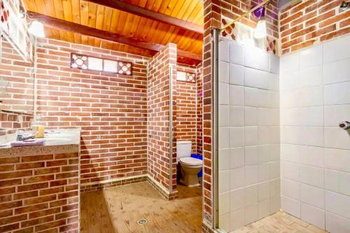 a brick bathroom with a shower and a toilet at Finca Hacienda el Morichal in Villavicencio