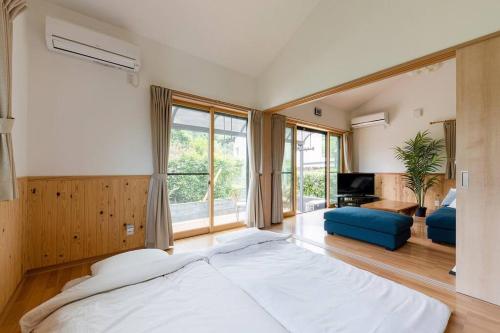 舞鶴市にあるSeaside Villa Nagiの大きなベッドルーム(大型ベッド1台付)、リビングルームが備わります。