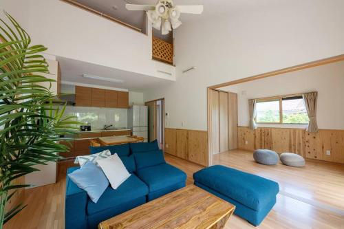 a living room with a blue couch and a table at Seaside Villa Nagi in Maizuru