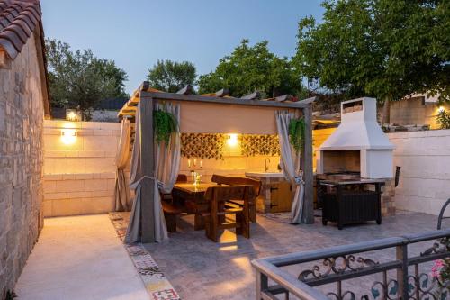 eine Terrasse mit einem Tisch und einem Grill in der Unterkunft Villa Lady Stone in Lovreć