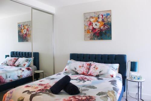 a bedroom with a bed with flowers on it at Modern apartment with water view in Geelong in Geelong