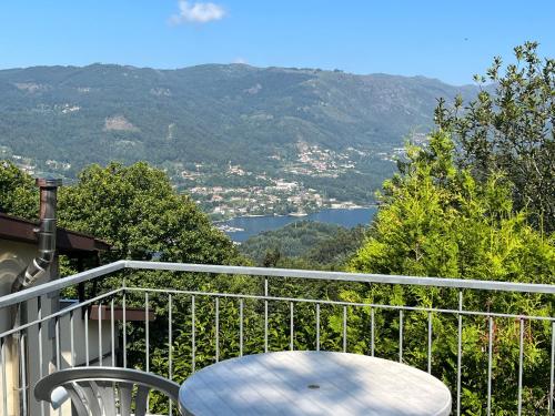 a table and chair on a balcony with a view at Casa de Casarelhos - Andar da Moradia com terraço - Vistas rio - "Gerês" in Geres