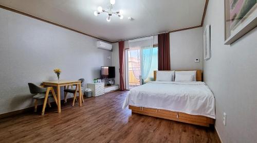 a bedroom with a bed and a desk and a table at Suncheon Bay Ecology Pension in Suncheon