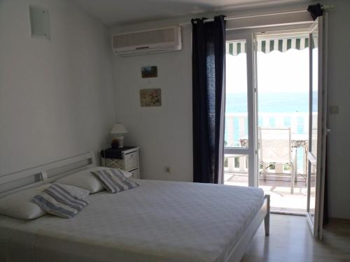 a bedroom with a bed with a view of the ocean at Apartments by the sea Rogoznica - 4805 in Rogoznica