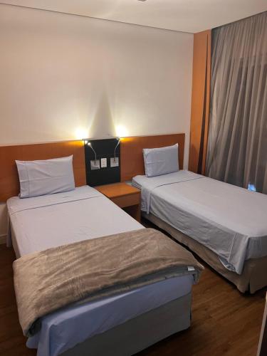 duas camas num quarto de hotel com em Flat Ibirapuera Jardins SP com garagem inclusa! em São Paulo