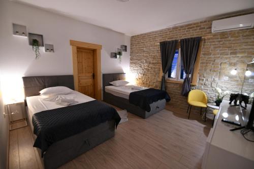 Cette chambre d'hôtel dispose de 2 lits et d'un mur en briques. dans l'établissement Family friendly house with a swimming pool Sinj, Zagora - 21448, à Sinj