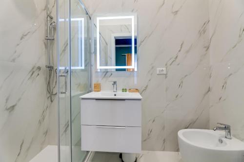 a white bathroom with a sink and a shower at Suri Suites in Rome