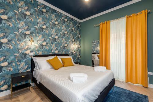 1 dormitorio con 1 cama y papel pintado con motivos florales en Suri Suites, en Roma