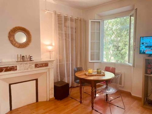 un salon avec une table et une cheminée dans l'établissement Studio dans très belle Bastide 18ème siècle, à Aix-en-Provence