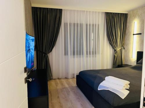 um quarto de hotel com uma cama e cortinas em Impact Apartments em Piteşti
