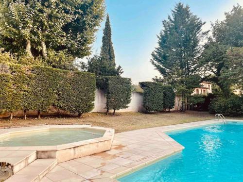 - une piscine dans une cour avec des arbres et des buissons dans l'établissement Studio dans très belle Bastide 18ème siècle, à Aix-en-Provence