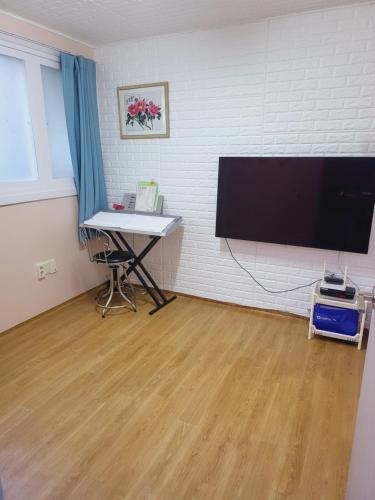 Sacheon Stay في ساتشيون: غرفة بها تلفزيون بشاشة مسطحة ومكتب