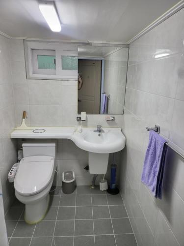 Sacheon Stay في ساتشيون: حمام ابيض مع مرحاض ومغسلة