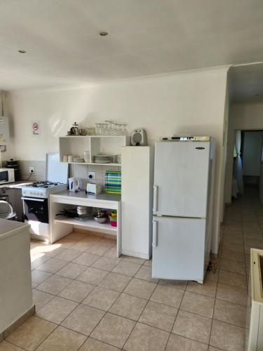 a kitchen with white appliances and a white refrigerator at Serenity Nhabanga, Bilene in Nhabanga