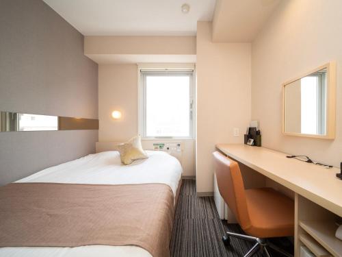 a hotel room with two beds and a desk at Super Hotel Premier Akasaka in Tokyo