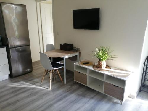 a kitchen with a desk and a table and a refrigerator at Carolina Studio in Maia