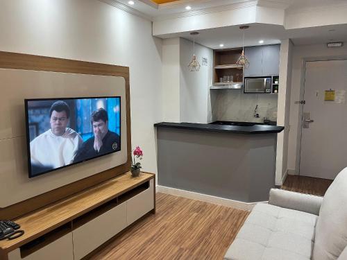 a living room with a flat screen tv on a wall at Flat Premium -Acesso a pé ao shopping Center vale - Edifício Summit (Ar condicionado) in São José dos Campos